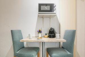 ein Tisch mit zwei blauen Stühlen und ein Tisch mit einem Tisch in der Unterkunft Simplon Residence - Central and Self Check In in Lausanne + 149 Fotos