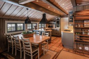 une cuisine avec une table et des chaises en bois dans l'établissement Large cabin with spectacular views in Geilo, à Geilo