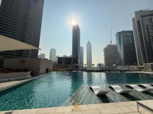 een groot zwembad in een stad met hoge gebouwen bij Evasion Moderne a Business Bay vue sur le canal in Dubai