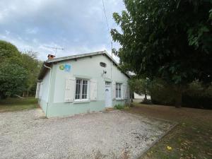 a small white house with a door and a window at Gîte de Peyrusse in Meauzac +3 photos