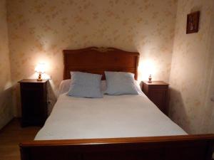 a bedroom with a large bed with two night stands at Gîte de Peyrusse in Meauzac