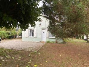 a white house with a white door and a tree at Gîte de Peyrusse in Meauzac