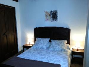 une chambre avec un lit avec deux lampes sur deux tables dans l'établissement Gîte de Raoussou, à Mirabel