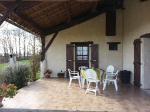 d'une terrasse avec des chaises blanches et une table. dans l'établissement Gîte de Raoussou, à Mirabel 6 autres photos