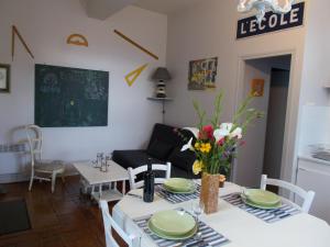 a living room with a table and chairs with flowers on it at Gîte Communal "Ecole" in Montain