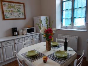 a dining room table with a vase of flowers on it at Gîte Communal "Ecole" in Montain