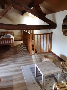 sala de estar con suelo de madera y mesa en Gîte de Brunenc, en Saint-Vincent-lʼEspinasse