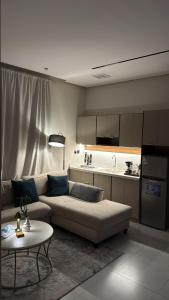a living room with a couch and a table and a kitchen at Elegant and classy apartment in Al Faisaliah neighborhood in Jeddah
