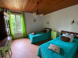 Un dormitorio con dos camas y una ventana en Gîte Borie, en Gasques