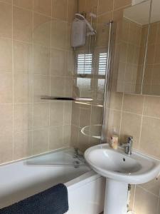 un bagno con un lavandino, una vasca, un water e uno specchio di Fun by the Sea a Hartlepool