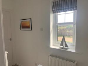 una stanza con una finestra con una barca a vela giocattolo al suo interno di Fun by the Sea a Hartlepool