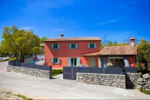 ein großes rotes Haus mit einer Steinmauer in der Unterkunft Villa Piano in Brest
