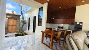 a kitchen with a wooden table and a dining room at Pondok Murni Mesari in Mantaak