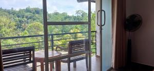 een kamer met een balkon met een tafel en 2 stoelen bij Tulip Heights Apartment in Daulagala