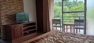 een slaapkamer met een bed en een tv op een dressoir bij Tulip Heights Apartment in Daulagala