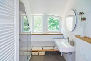 une salle de bain avec un lavabo et deux fenêtres dans l'établissement Charming Flat In Historic Country House, à Meezen