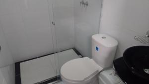 une salle de bain avec des toilettes blanches et une douche dans l'établissement VALASIUK Sede San Fernando, à Villavicencio
