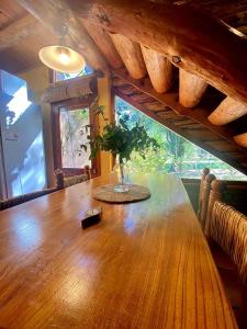 a large wooden table in a room with a window at Cabaña Paihuen in Villa General Belgrano