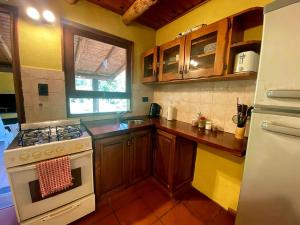 a kitchen with a stove and a sink at Cabaña Paihuen in Villa General Belgrano