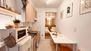 eine kleine Küche mit Mikrowelle und Tisch in der Unterkunft Exit 4 of Hongik University in Samgong-ni + 25 Fotos