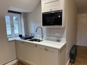 una cocina con fregadero y microondas en Queen's Terrace Apartments, en Exeter