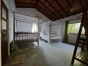 a bedroom with a bed with a net canopy at Asoka's Place in Unawatuna