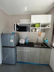 een kleine keuken met een koelkast en een magnetron bij AC Home 1 Laksi in Lak Si