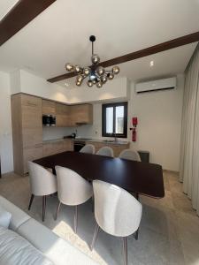 a dining room with a black table and chairs at Hawana Salalah Resort - FV 5 in Salalah