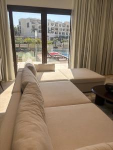 a living room with a couch and a large window at Hawana Salalah Resort - FV 5 in Salalah +22 photos