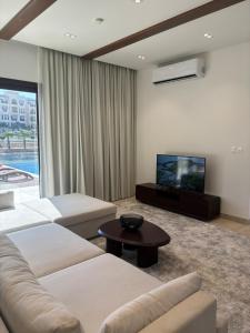 a living room with two couches and a flat screen tv at Hawana Salalah Resort - FV 5 in Salalah
