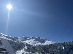 ein Licht auf einem schneebedeckten Berg in der Unterkunft Studio rénové avec balcon, au pied des pistes, accès WIFI - FR-1-787-53 in Laveissière