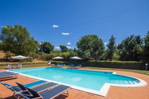 a large swimming pool with chairs and umbrellas at La Fontaccia 10 by VacaVilla in Montiano