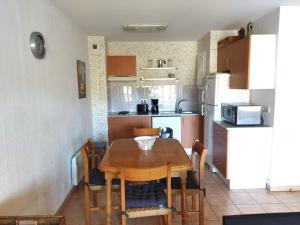 eine Küche mit Tisch und Stühlen und eine Küche mit Kühlschrank in der Unterkunft Appartement T2 cabine pour 6 personnes avec parking à Vieux-Boucau - FR-1-379-146 in Vieux-Boucau-les-Bains + 7 Fotos