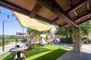 a patio with a table and chairs on the grass at La Fontaccia 10 by VacaVilla in Montiano +18 photos