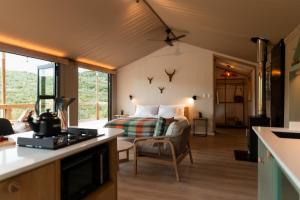 sala de estar con cama y sofá en una habitación en AfriCamps Magoebaskloof, en Magoebaskloof