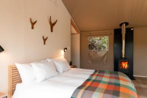 1 dormitorio con 1 cama con chimenea en AfriCamps Magoebaskloof, en Magoebaskloof