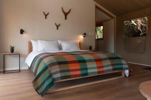 a bedroom with a bed with a colorful blanket at AfriCamps Magoebaskloof in Magoebaskloof