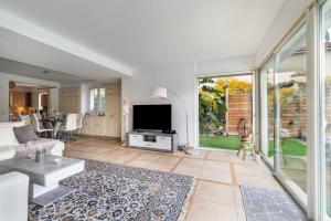 ein Wohnzimmer mit Sofa und Fernseher in der Unterkunft Villa 8 personnes bord de mer in Cros-de-Cagnes