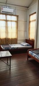 une chambre avec deux lits et deux fenêtres dans l'établissement Rareheart Guesthouse, à Kuala Terengganu