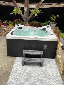 ein Whirlpool mit einer Bank in einem Garten in der Unterkunft Domaine Cherps Spa - Zen in Vielleségure
