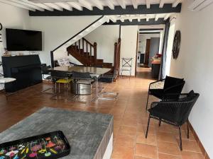 un salon avec des chaises, une table et une télévision dans l'établissement Domaine Cherps Spa - Sérénité, à Vielleségure