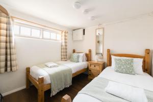 une chambre avec deux lits et une fenêtre dans l'établissement Shepherds Rest Cotswolds Cottage Farm Stay With Pool, à Lechlade 133 autres photos