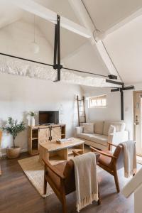 un salon avec un canapé et une table dans l'établissement Shepherds Rest Cotswolds Cottage Farm Stay With Pool, à Lechlade