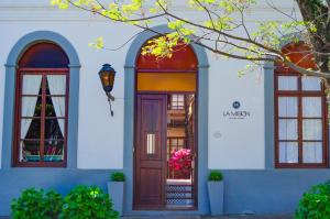 科洛尼亚-德尔萨克拉门托拉米圣酒店的一座带木门和两扇窗户的房子