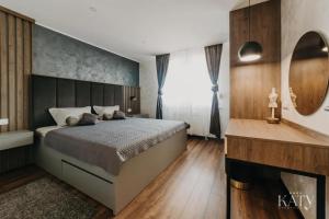 a bedroom with a large bed and a fireplace at Apartman KATY in Vukovar