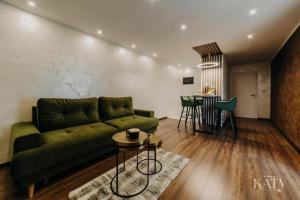 a living room with a green couch and a table at Apartman KATY in Vukovar
