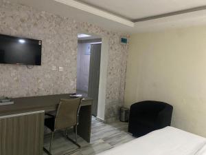 um quarto de hotel com uma secretária e uma televisão na parede em House 32 Hotels and Suites em Lagos