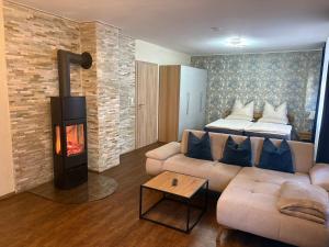 a living room with a couch and a fireplace at 1-Zimmer-Apartment mit Pool und Kamin in Ellenz-Poltersdorf