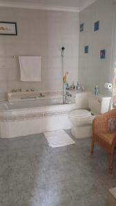 y baño blanco con aseo y bañera. en EL Golfview, en De Deur