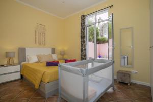 a bedroom with a bed and a tub and a window at Furnas Cozy Inn in Furnas